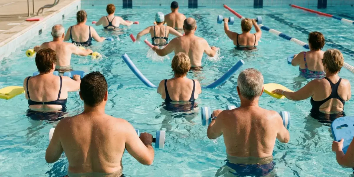 Groupe faisant aquatraining dans piscine avec accessoires